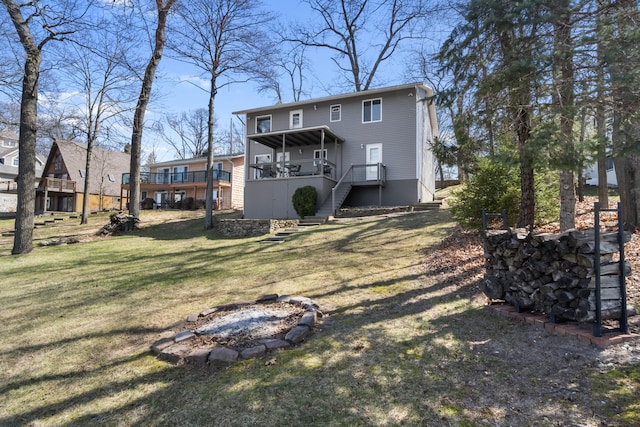 11672 Bradley Dr, Jerome, MI 49249 - rear view of house featuring stairs, a fire pit, and a lawn