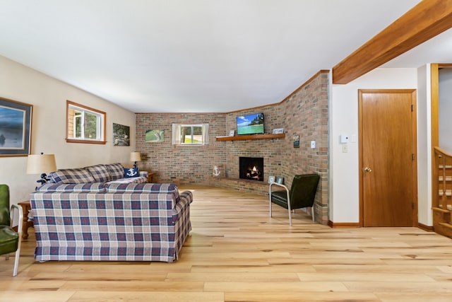 11672 Bradley Dr, Jerome, MI 49249 - living area featuring wood finished floors, brick wall, and a fireplace