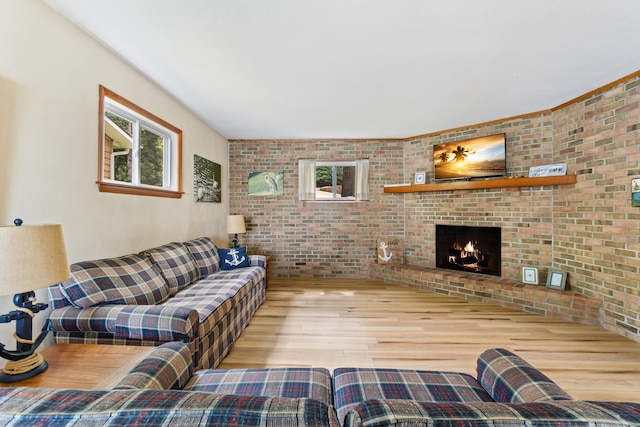 11672 Bradley Dr, Jerome, MI 49249 - living room featuring wood finished floors, brick wall, and a fireplace