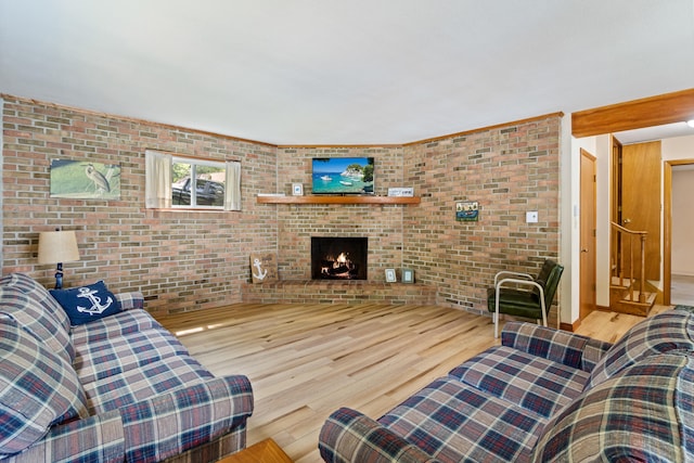 11672 Bradley Dr, Jerome, MI 49249 - living area with wood finished floors, brick wall, and a fireplace