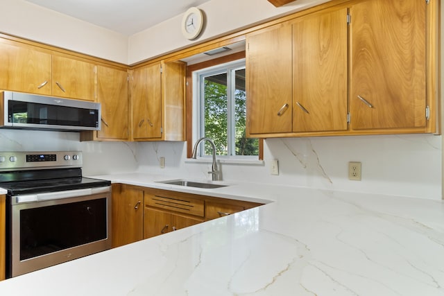11672 Bradley Dr, Jerome, MI 49249 - kitchen featuring appliances with stainless steel finishes, light stone countertops, tasteful backsplash, and brown cabinets