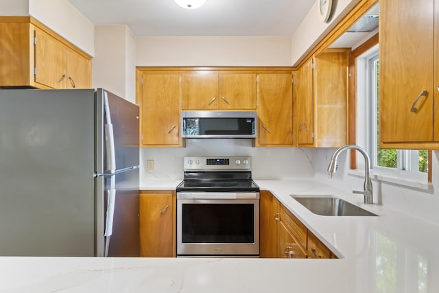 11672 Bradley Dr, Jerome, MI 49249 - kitchen featuring appliances with stainless steel finishes, light countertops, and brown cabinets