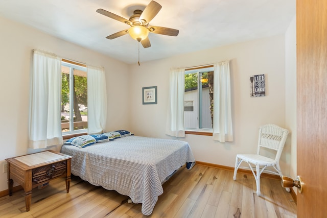 11672 Bradley Dr, Jerome, MI 49249 - bedroom featuring multiple windows, wood finished floors, and a ceiling fan