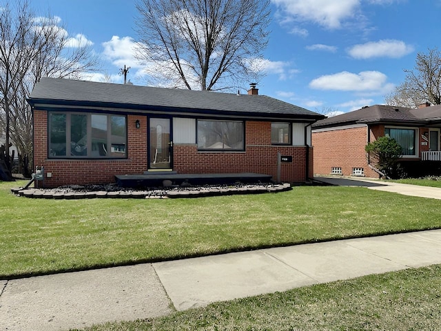 22169 Fairfax St, Taylor, MI 48180 - view of front of home with a chimney, brick siding, and a front yard