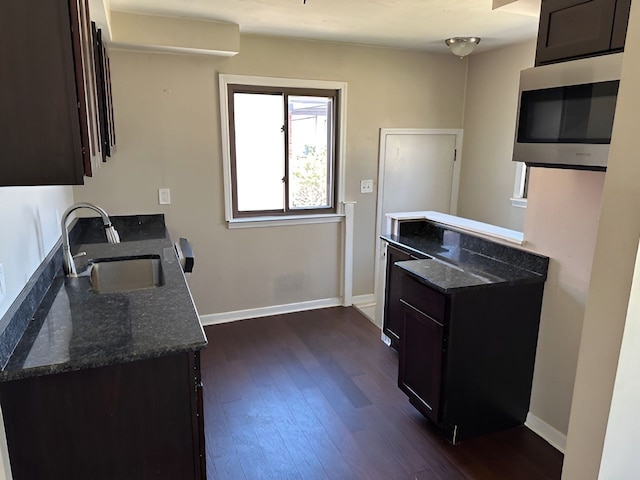 22169 Fairfax St, Taylor, MI 48180 - kitchen featuring dark wood finished floors, stainless steel microwave, dark stone counters, and a sink