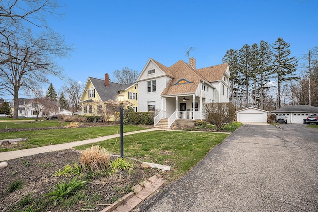 359 Pearl St, South Haven, MI 49090 - view of front of property with a ceiling fan, a garage, a chimney, an outbuilding, and a front lawn