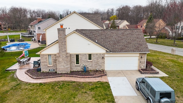 view of front facade featuring roof with shingles, a front lawn, driveway, brick siding, and an attached garage