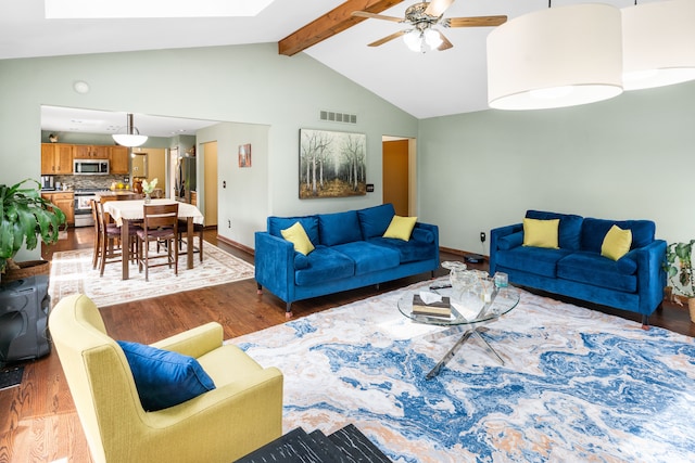 living area featuring visible vents, a ceiling fan, baseboards, light wood-style flooring, and high vaulted ceiling