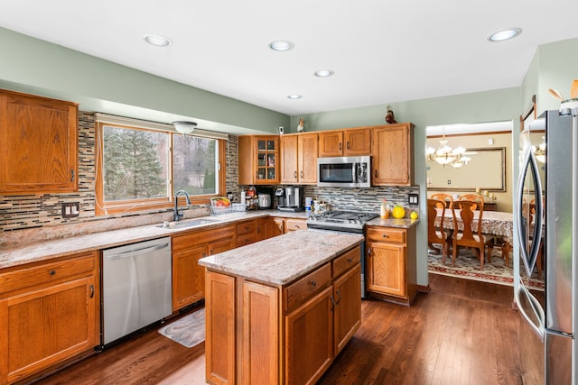 kitchen featuring a chandelier, decorative backsplash, stainless steel appliances, and a sink