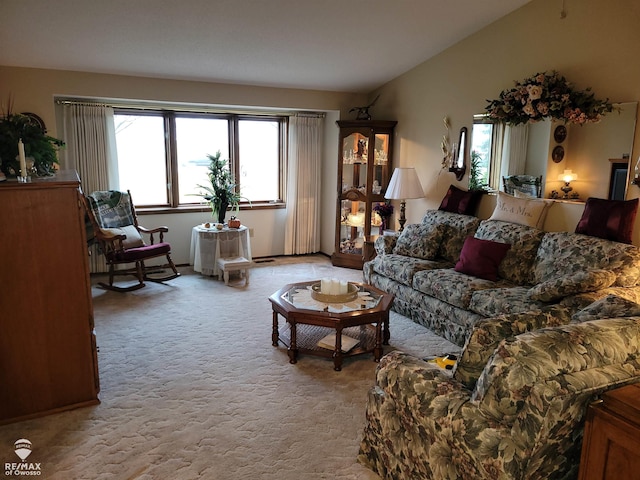 carpeted living room with lofted ceiling and a healthy amount of sunlight