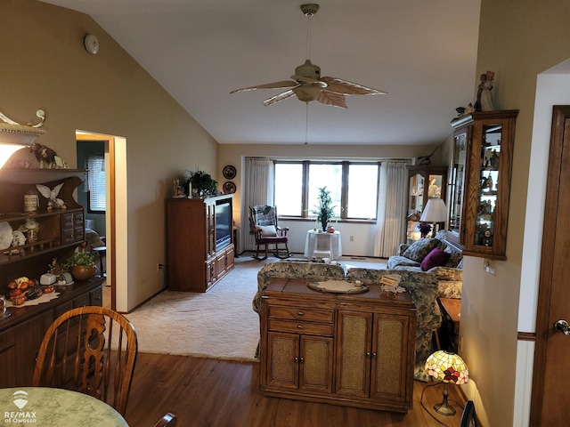 living area with wood finished floors, a ceiling fan, and vaulted ceiling