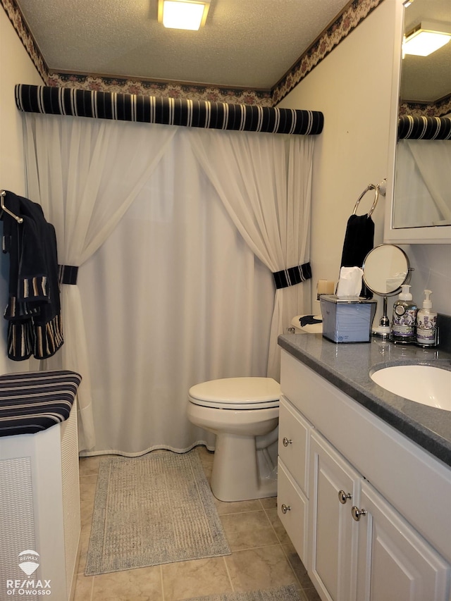 full bathroom with tile patterned floors, vanity, a textured ceiling, and toilet