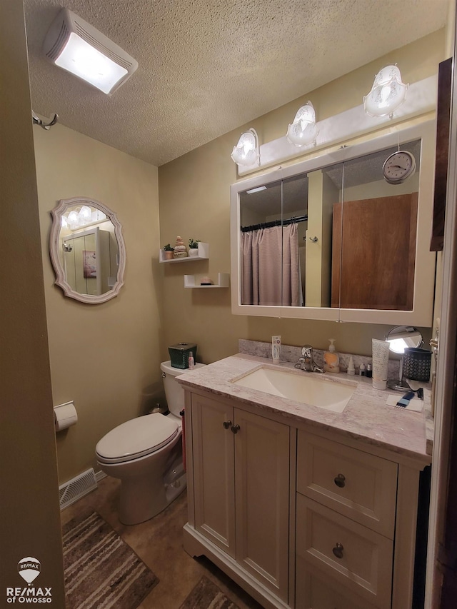bathroom featuring toilet, a textured ceiling, vanity, and visible vents