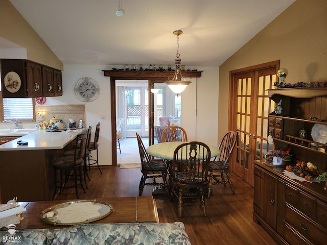 dining area with dark wood-style floors and vaulted ceiling