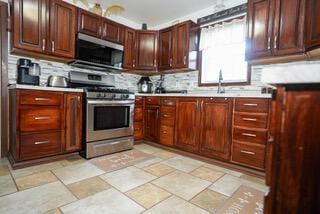 kitchen featuring backsplash, light countertops, and appliances with stainless steel finishes