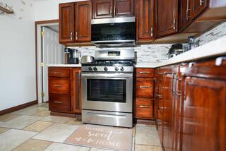kitchen with light countertops, baseboards, and gas stove