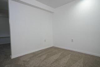 unfurnished room featuring carpet floors and baseboards