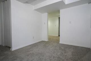 carpeted empty room with baseboards