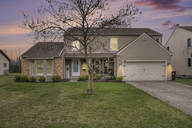 traditional home with a shingled roof, a yard, driveway, and a garage