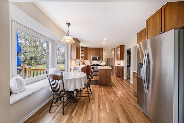 dining room with baseboards, light wood finished floors, and recessed lighting