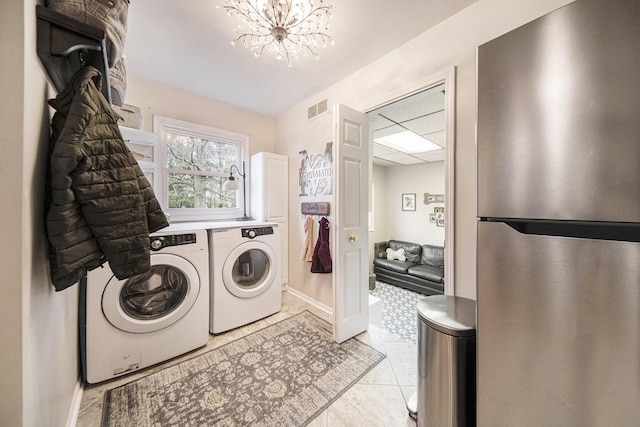laundry room with visible vents, light tile patterned floors, baseboards, a notable chandelier, and independent washer and dryer