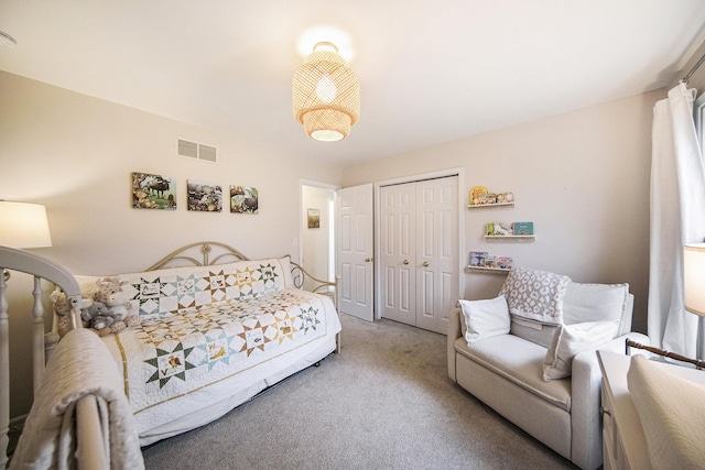 carpeted bedroom with visible vents and a closet