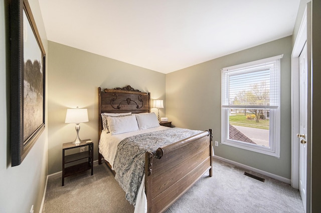 bedroom with light carpet, visible vents, and baseboards