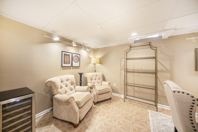 living area with baseboards and wine cooler