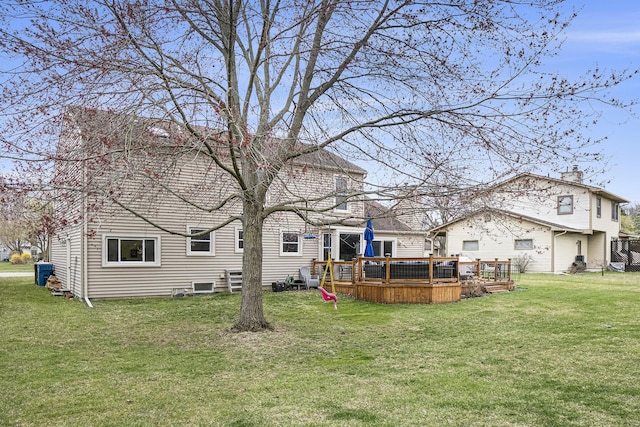 rear view of property with a deck and a lawn