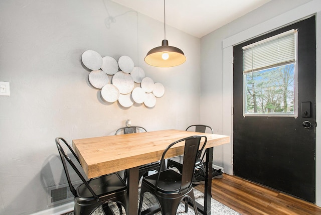 dining space featuring wood finished floors and lofted ceiling