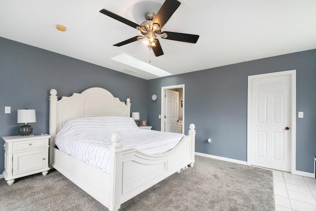 bedroom featuring baseboards, a ceiling fan, light tile patterned flooring, visible vents, and a skylight