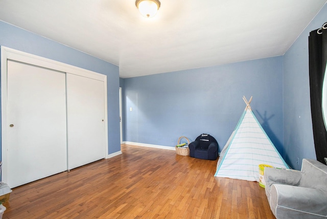 interior space with a closet, baseboards, and wood finished floors