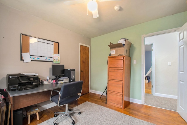 office area with baseboards, a ceiling fan, and wood finished floors
