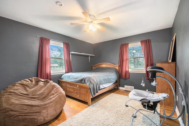 bedroom with visible vents, a ceiling fan, and wood finished floors