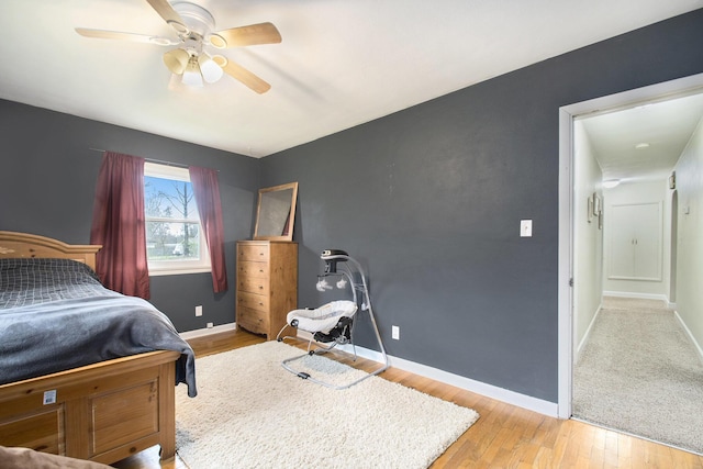 bedroom featuring ceiling fan, baseboards, and wood finished floors