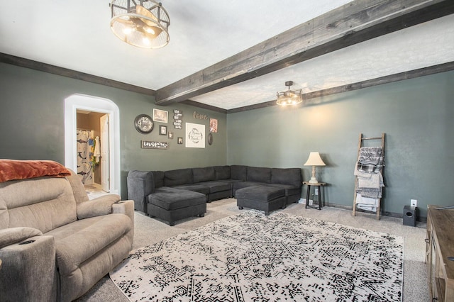 living room featuring baseboards, arched walkways, ceiling fan, beamed ceiling, and carpet flooring