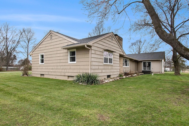 view of property exterior with a yard, crawl space, and a chimney