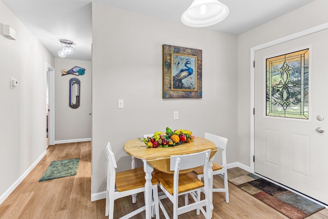 dining room with baseboards and light wood-style flooring
