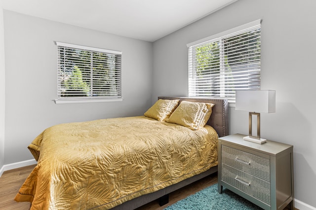 bedroom with baseboards and wood finished floors