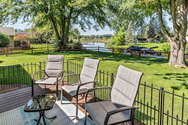 deck featuring a lawn, a water view, and a fenced backyard