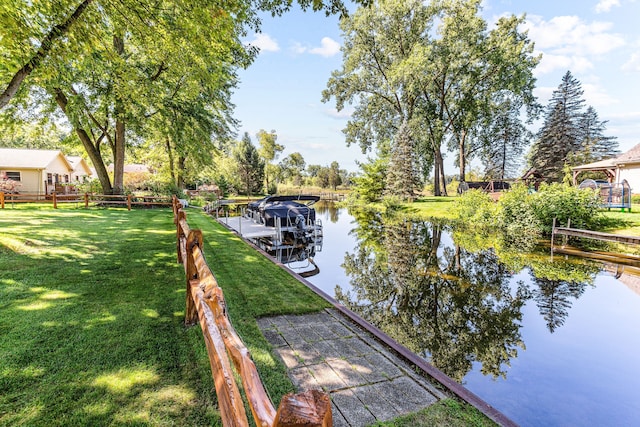dock area featuring a lawn, a water view, and fence