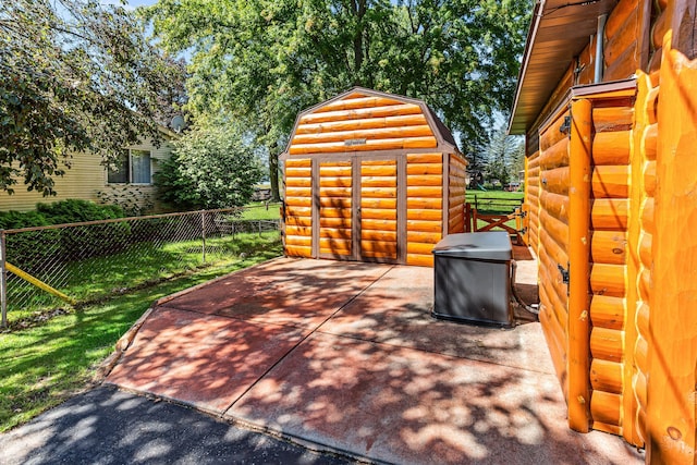 view of patio with fence, a storage unit, and an outdoor structure
