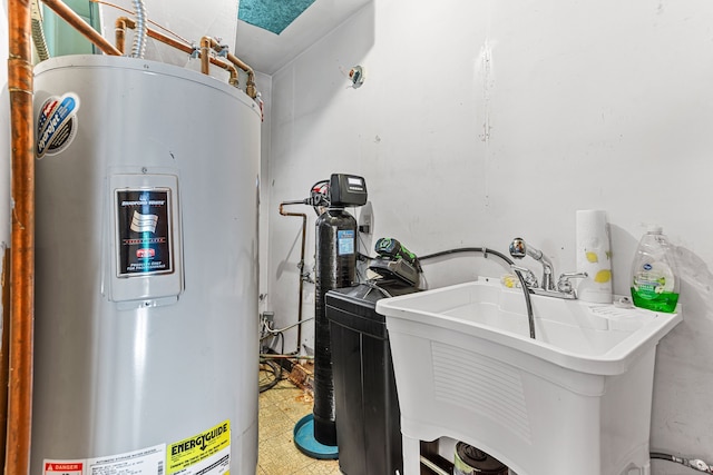 clothes washing area featuring a sink, water heater, and light floors