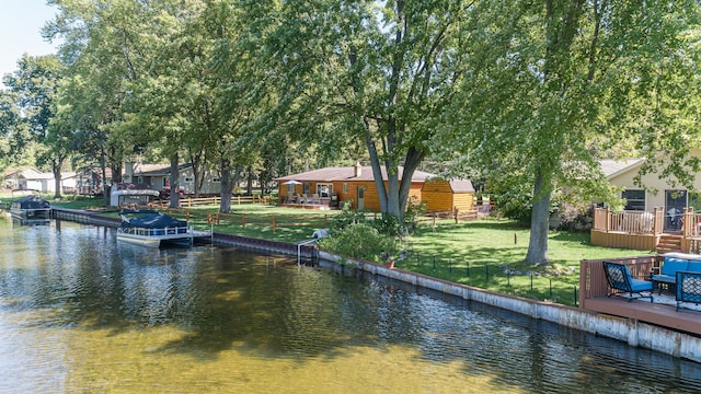 dock area with a yard and a deck with water view