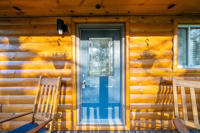 view of exterior entry with faux log siding