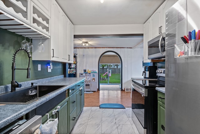 21160 Inkster Rd, Southfield, MI 48033 - kitchen featuring appliances with stainless steel finishes, a sink, light countertops, marble finish floor, and white cabinetry