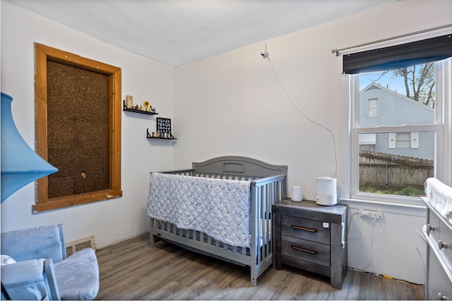 21160 Inkster Rd, Southfield, MI 48033 - bedroom featuring a nursery area, visible vents, and wood finished floors