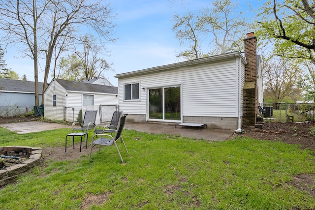 21160 Inkster Rd, Southfield, MI 48033 - rear view of house featuring fence, an outdoor fire pit, a chimney, a patio area, and a yard