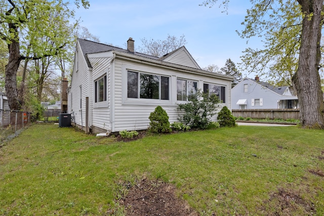 21160 Inkster Rd, Southfield, MI 48033 - exterior space featuring a lawn, central AC unit, fence, and a chimney