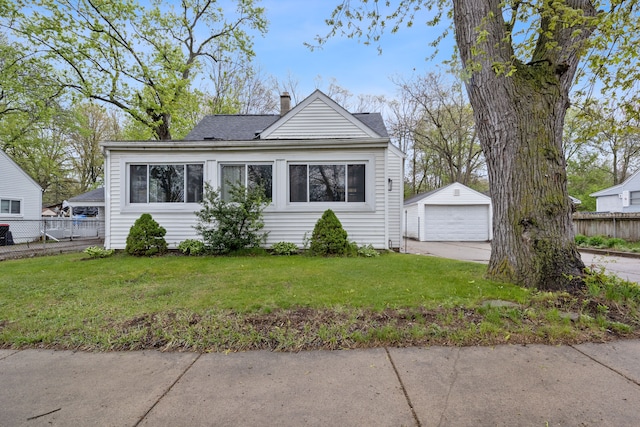 21160 Inkster Rd, Southfield, MI 48033 - bungalow-style house featuring a chimney, an outbuilding, a detached garage, fence, and a front lawn